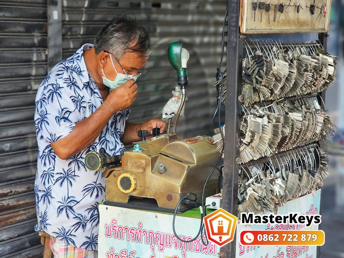 thợ khóa lưu động kiểm tra chìa cắt theo ảnh trước khi giao cho khách