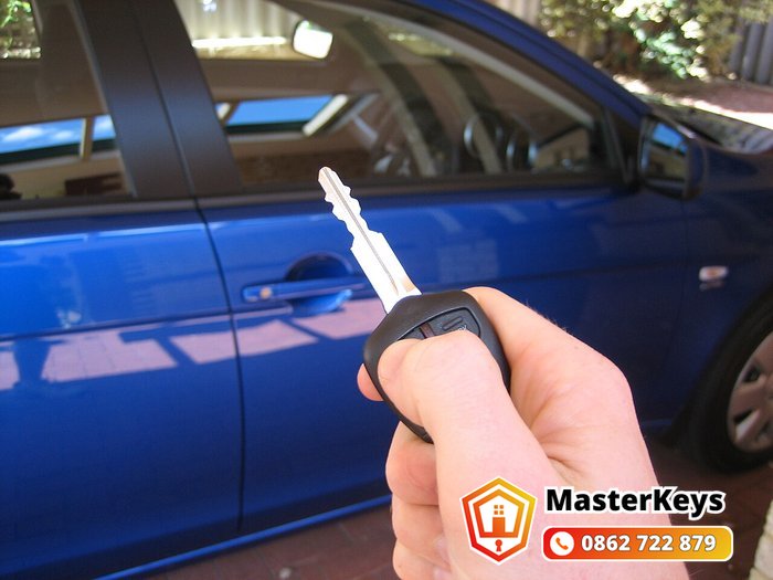 Chìa khóa remote ô tô cầm trên tay trước cửa xe